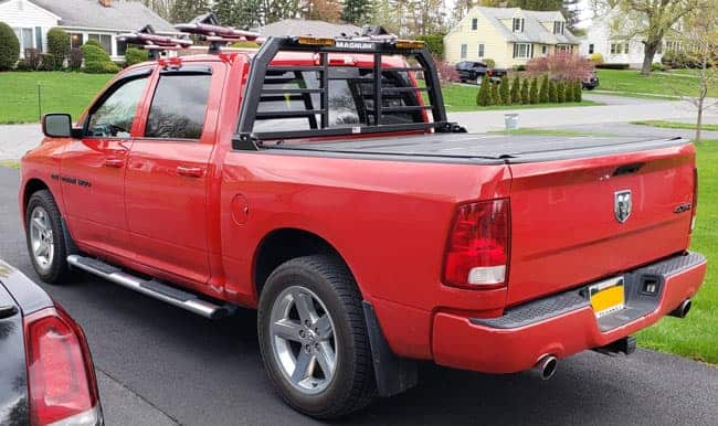 Red Dodge Ram with a tonneau cover and Magnum truck rack