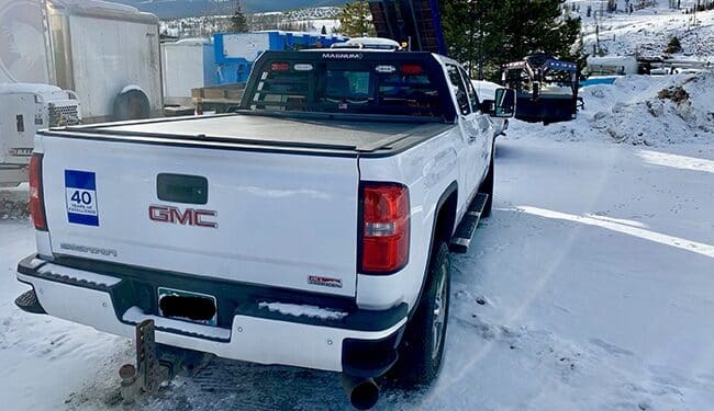 White GMC pickup with a Magnum headache rack and tonneau cover for truck bed