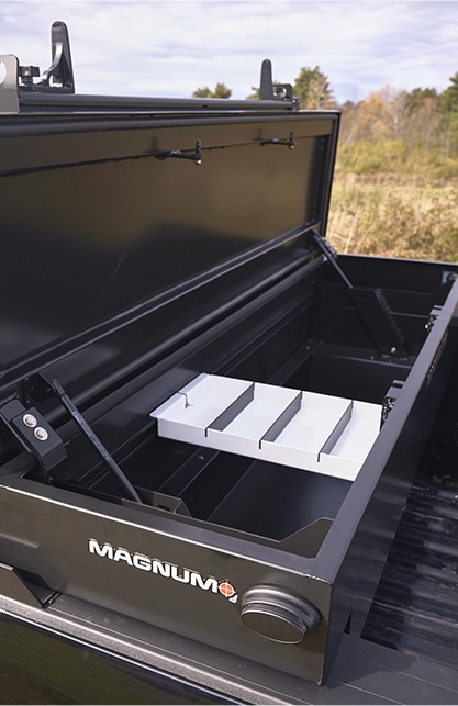 open lid on truck bed toolbox showing white inner tool tray - mounted in back of black pickup truck